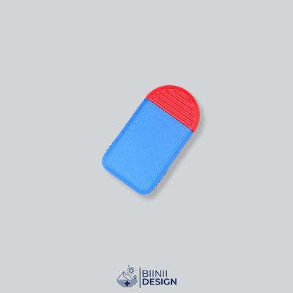 Pilulier compact 2 compartiments avec couvercle bleu et base rouge, pour 2 prises par jour.