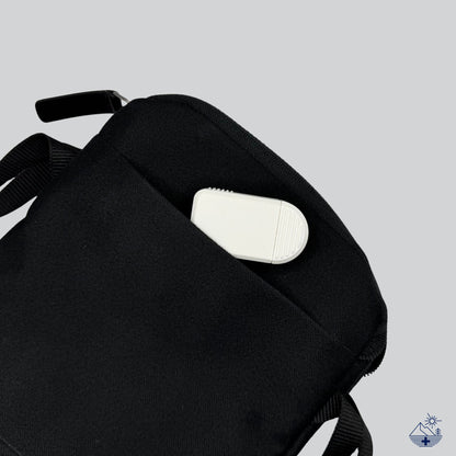 Pilulier compact 2 compartiments blanc rangé dans une petite pochette zippée, couvercle coulissant fermé sur les deux compartiments.