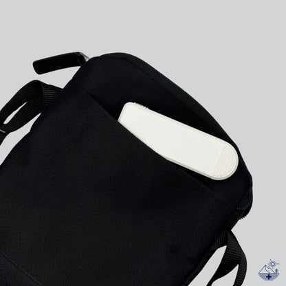 Pilulier compact 4 compartiments blanc rangé dans une petite pochette zippée, couvercle coulissant fermé sur les 4 compartiments.