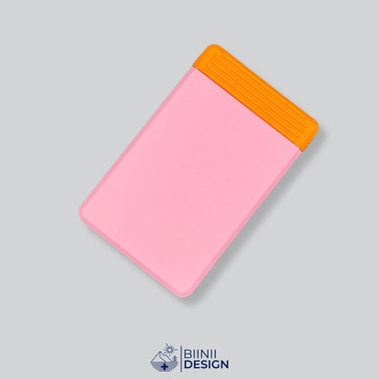 Pilulier de voyage double rangée avec couvercle rose et base orange, quatre grands compartiments.