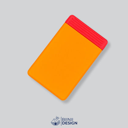 Semainier compact avec couvercle orange et base rouge, départ dimanche ou lundi.