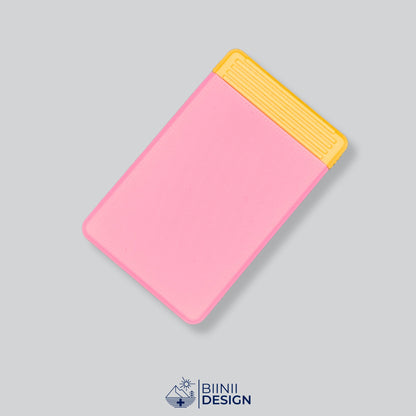 Semainier compact avec couvercle rose et base jaune, départ dimanche ou lundi.