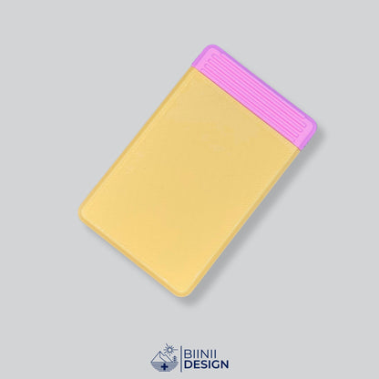 Semainier compact avec couvercle jaune et base rose, départ dimanche ou lundi.
