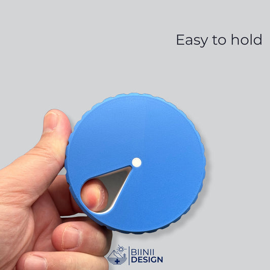 Blue and white round magnetic pill organizer shown closed in hand, demonstrating its compact size.