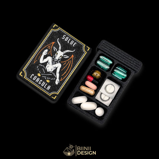 Baphomet symbolic organizer cover beside 5-compartment tray. Secure slide closure filled with supplements and medicines.