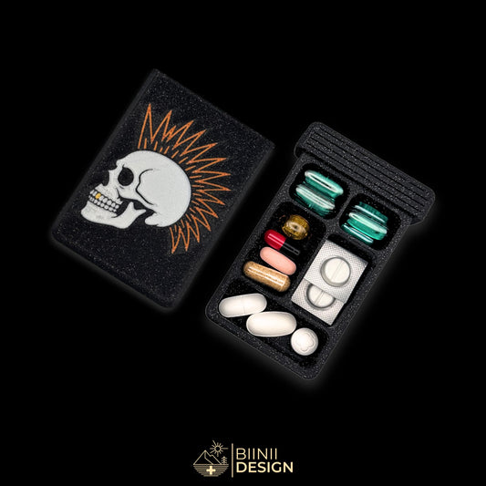 Punk Skull art pill organizer cover beside 5-compartment tray. Secure slide closure filled with supplements and medicines.
