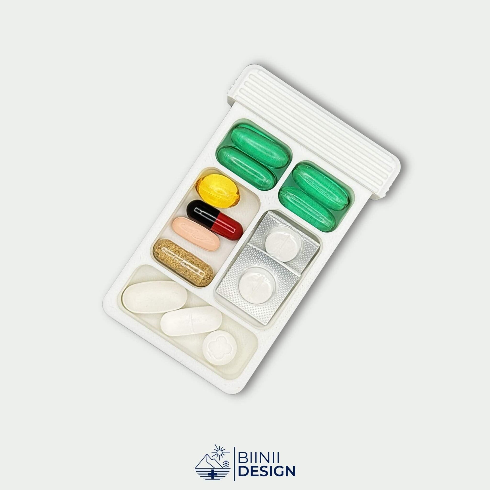 White 5-compartment pill organizer tray filled with tablets, capsules and blisters. Slim pill box for daily or travel use.