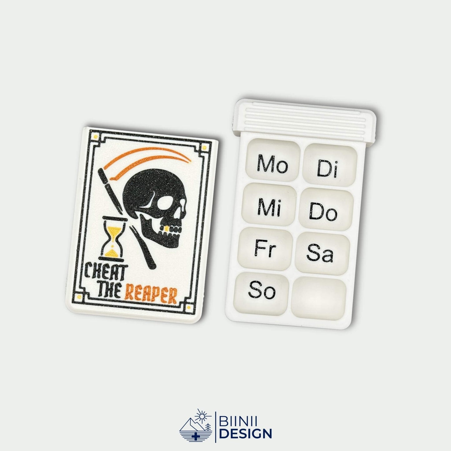 Cheat the Reaper White Edition cover next to white 8-compartment weekly tray with black German day markings. Wochenversion pill organizer.