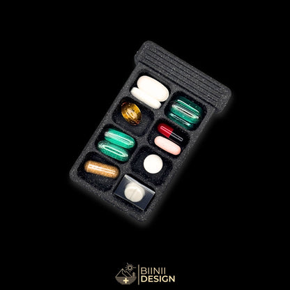 8-compartment base of the Sardines art edition pill organizer, filled with tablets, capsules and supplements of varied sizes.