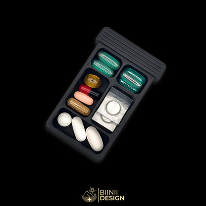 5-compartment base of the Vulture's Shadow art edition pill organizer: four cells and a full-width compartment filled with tablets and capsules.