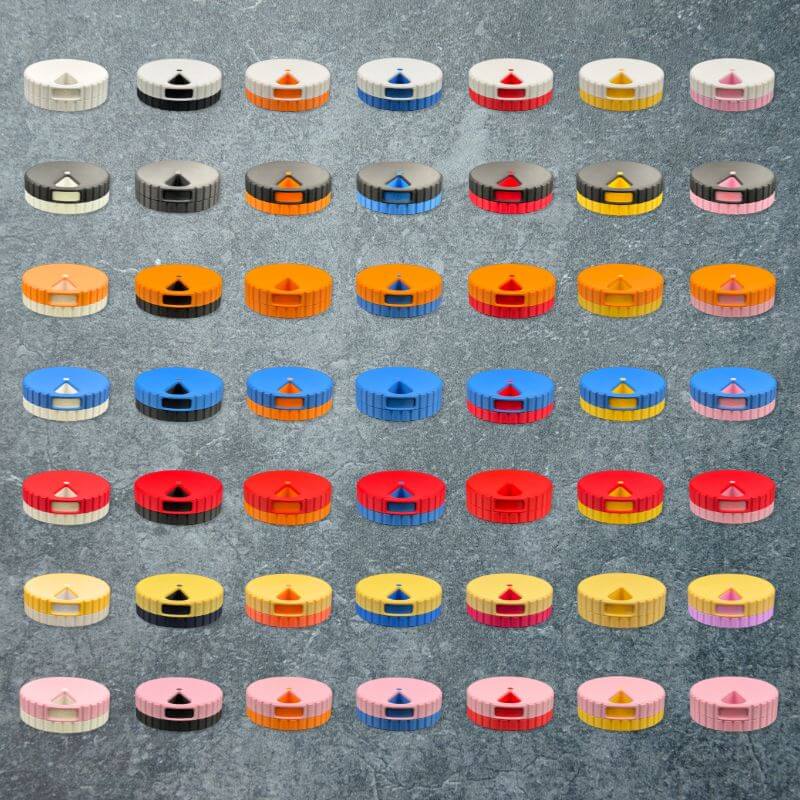 The 49 color combinations of the round weekly pill organizer, seven lid colors by seven base colors, laid out in a grid on slate.