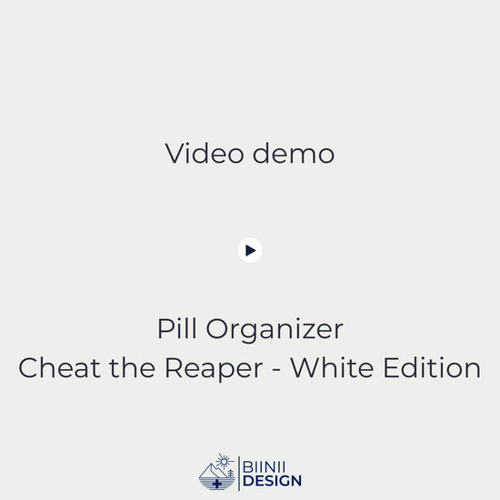 Video demonstration of the Cheat the Reaper White Edition sliding pill organizer opening and closing (5-compartment filled), then placed into its premium Swiss-made Biinii gift packaging.